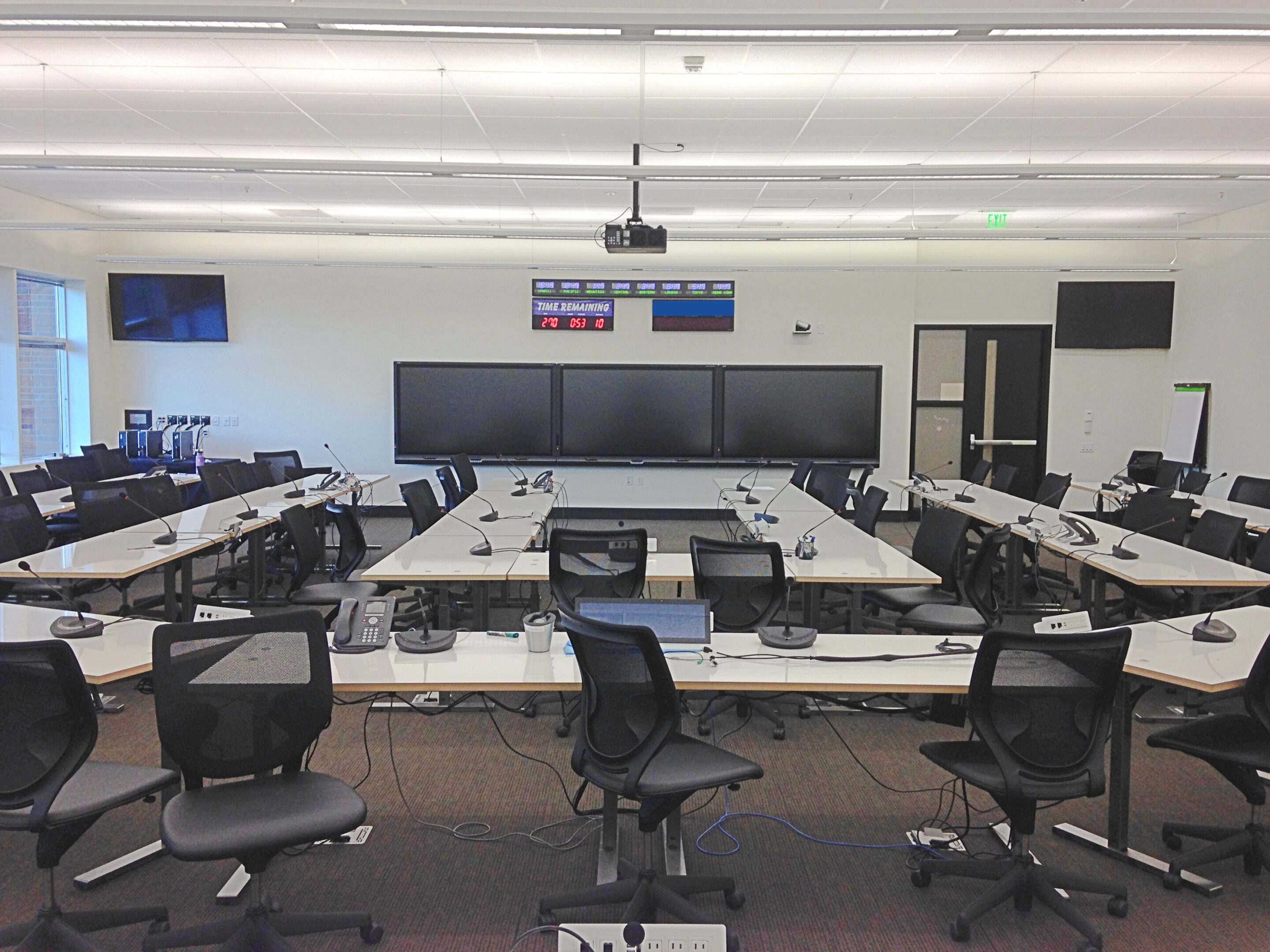Empty command center with multiple monitors and chairs